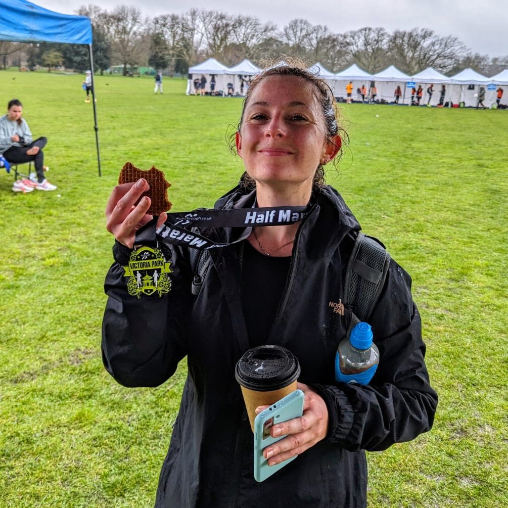 A photo of Alexandra proudly holding her medal from a Half Marathon